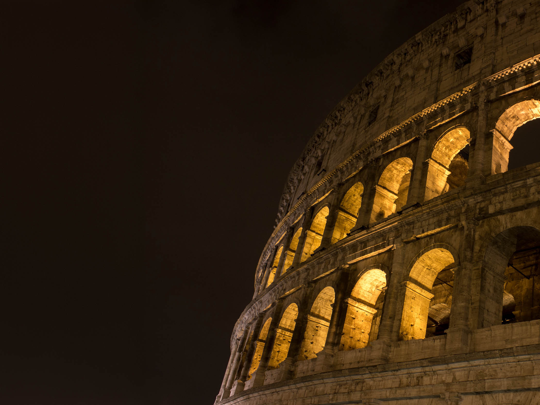 Low angle view of Coliseum at dusk in Rome, Italy. Coliseum with clear sky at night. Horizontal composition. Outdoors. It also known as the Flavian Amphitheatre. Coliseum is an oval amphitheatre in the centre of the city of Rome, Italy. Built of concrete and sand. It is the largest amphitheatre ever built. It was used for gladiatorial contests and public spectacles such as mock sea battles, animal hunts, executions, re-enactments of famous battles, and dramas based on Classical mythology.