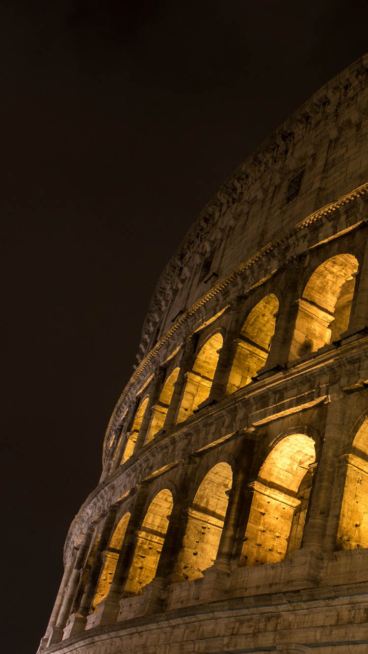 Low angle view of Coliseum at dusk in Rome, Italy. Coliseum with clear sky at night. Horizontal composition. Outdoors. It also known as the Flavian Amphitheatre. Coliseum is an oval amphitheatre in the centre of the city of Rome, Italy. Built of concrete and sand. It is the largest amphitheatre ever built. It was used for gladiatorial contests and public spectacles such as mock sea battles, animal hunts, executions, re-enactments of famous battles, and dramas based on Classical mythology.