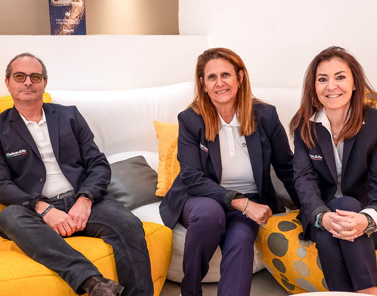 Trois personnes habill es en tenue professionnelle assises sur un canap blanc et jaune dans un environnement int rieur lumineux.  Description g n r e par IA