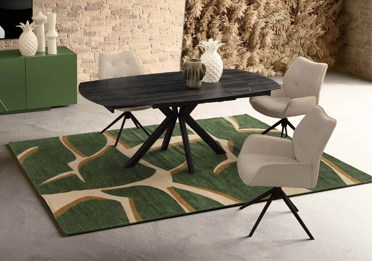 Une table noire moderne avec quatre chaises beige autour pos es sur un tapis vert  motifs beige dans une pi ce au sol clair et murs en pierre.  Description g n r e par IA