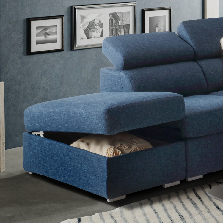 Canap d'angle bleu avec un coffre de rangement ouvert contenant une couverture beige dans un salon moderne avec des cadres photos accroch s au mur gris.  Description g n r e par IA