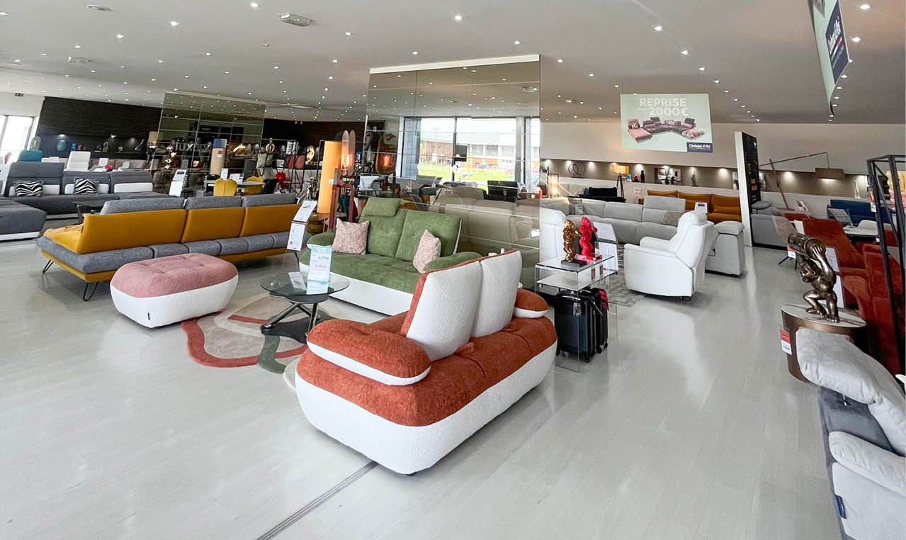 Grand showroom lumineux pr sentant plusieurs canap s modernes de diff rentes couleurs et styles dispos s sur un sol clair avec des d corations et accessoires contemporains. Description g n r e par IA