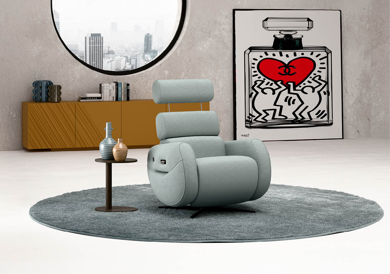 Fauteuil moderne gris clair avec appui-t te pos sur un tapis rond gris dans un salon minimaliste avec une table basse, une grande fen tre ronde et une  uvre d'art color e accroch e au mur.  Description g n r e par IA
