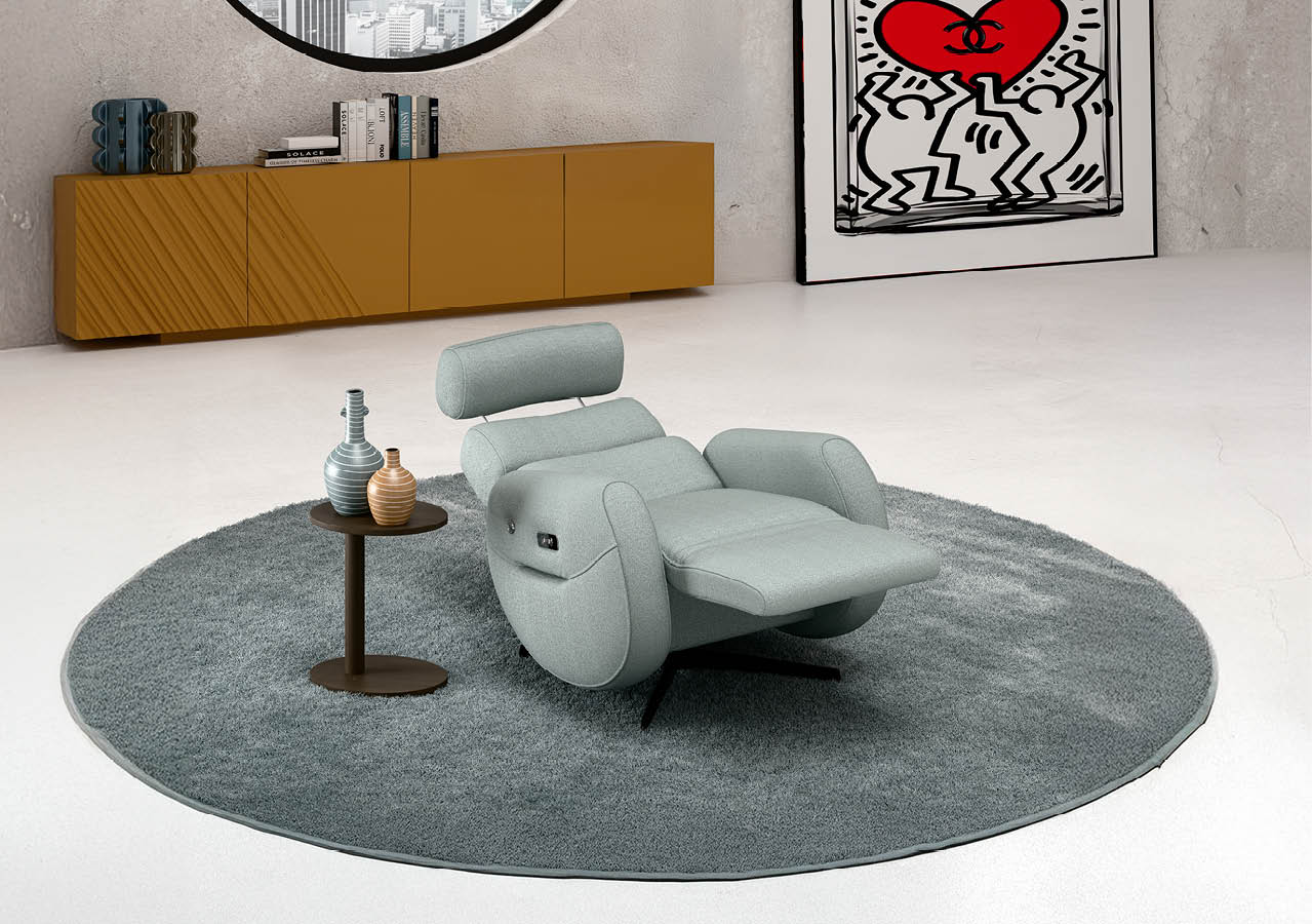 Fauteuil relax gris clair inclin avec repose-pieds sur un tapis rond gris dans un salon moderne avec un meuble bas marron et un tableau color  accroch  au mur.  Description g n r e par IA