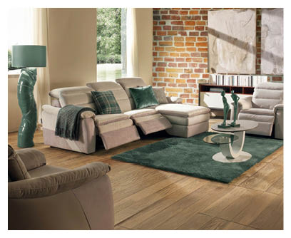 Salon moderne avec deux canap s gris, un fauteuil beige, une table basse ronde, un tapis, une plante en pot, un lampadaire et un escalier en b ton avec une rampe en verre. Description g n r e par IA