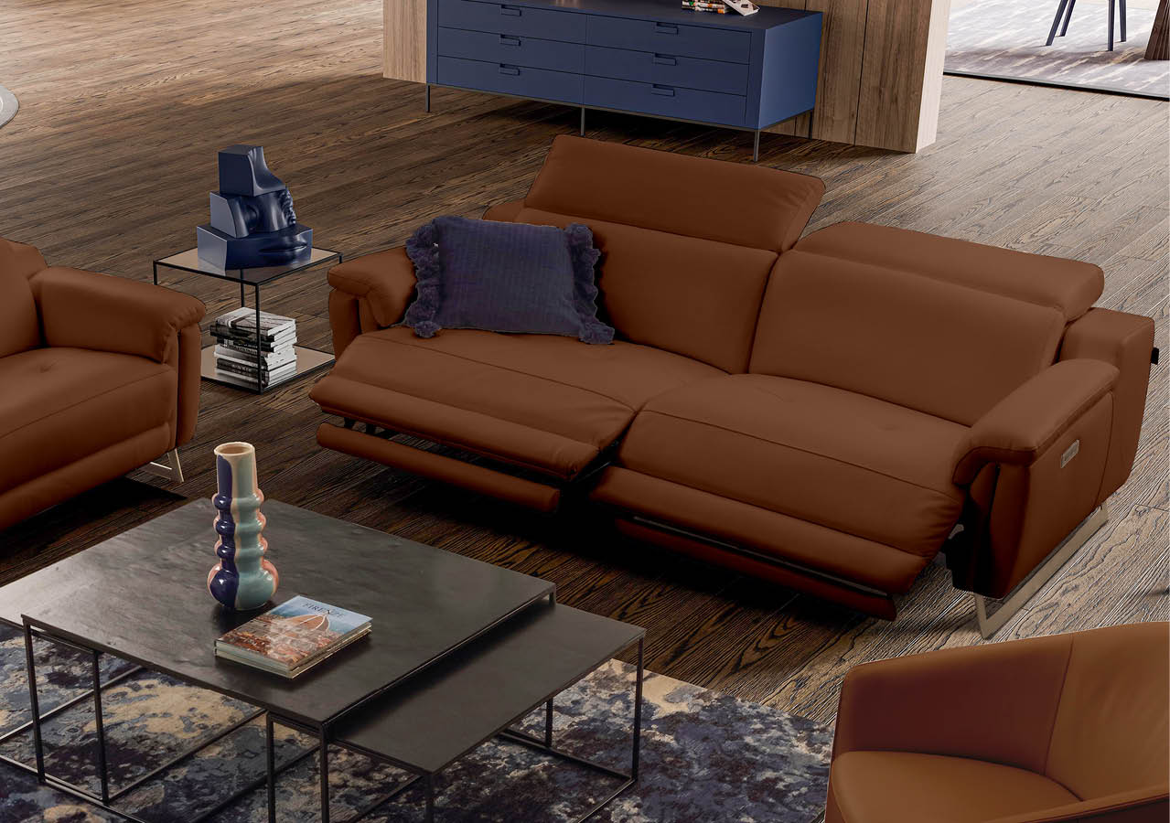 Canap en cuir marron avec repose-pieds relev s dans un salon moderne avec table basse noire, tapis et meuble de rangement bleu.  Description g n r e par IA