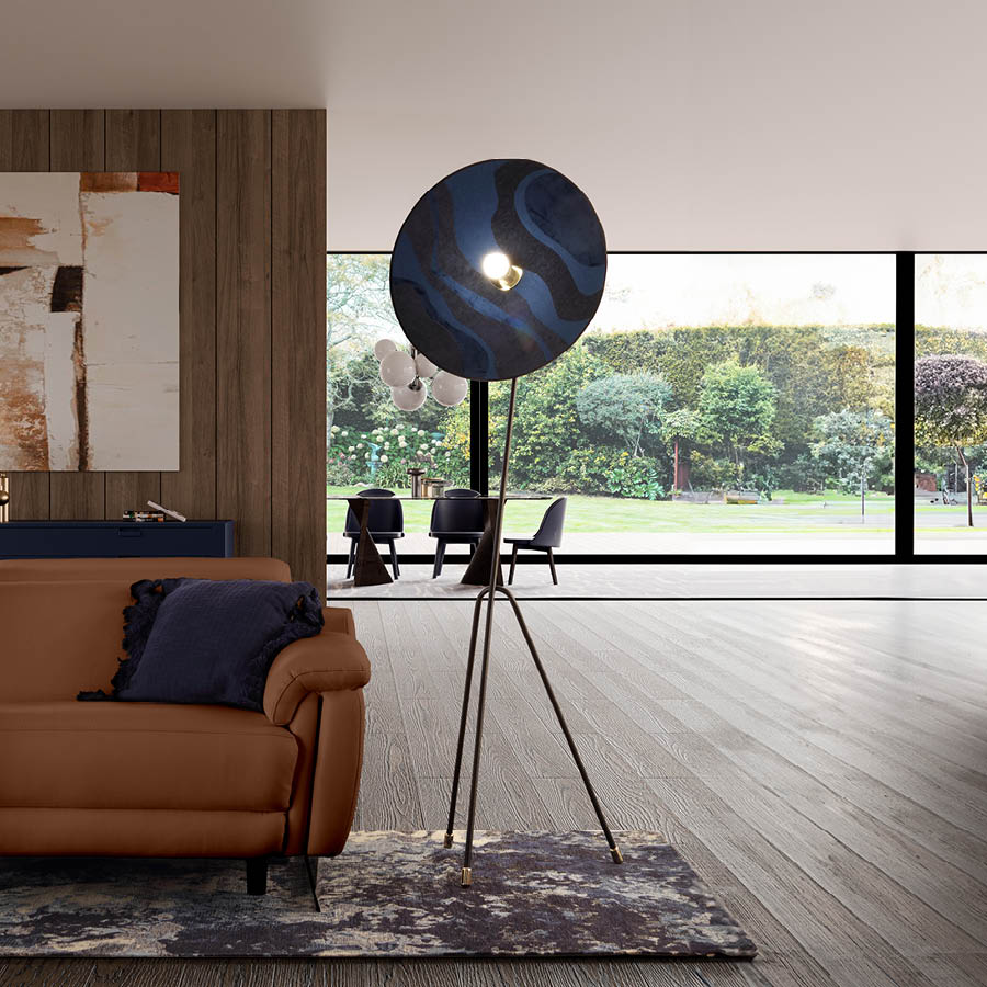 Un salon moderne avec un canap en cuir marron, un coussin bleu, une lampe sur pied design et une grande baie vitr e donnant sur un jardin verdoyant.  Description g n r e par IA