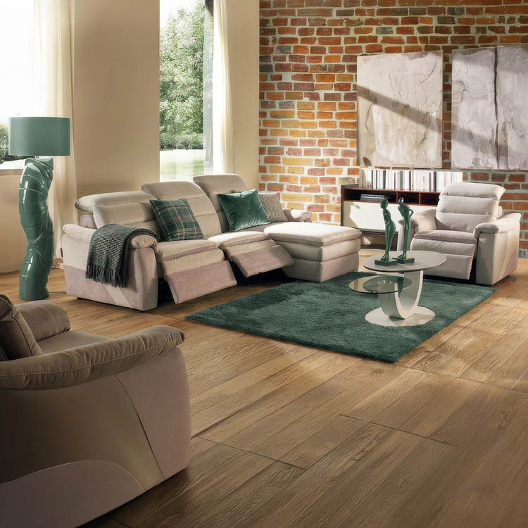 Un salon lumineux avec un canap beige   deux places  quip  de repose-pieds relevables, des coussins verts, un plaid, un tapis vert et une lampe au pied sculpt  pr s d'une fen tre avec des rideaux blancs.  Description g n r e par IA