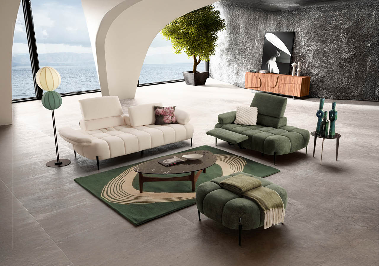 Salon moderne avec deux canap s et un pouf verts et blancs autour d'une table basse ovale sur un tapis vert, avec une grande fen tre donnant sur la mer et une plante en pot dans un coin. Description g n r e par IA