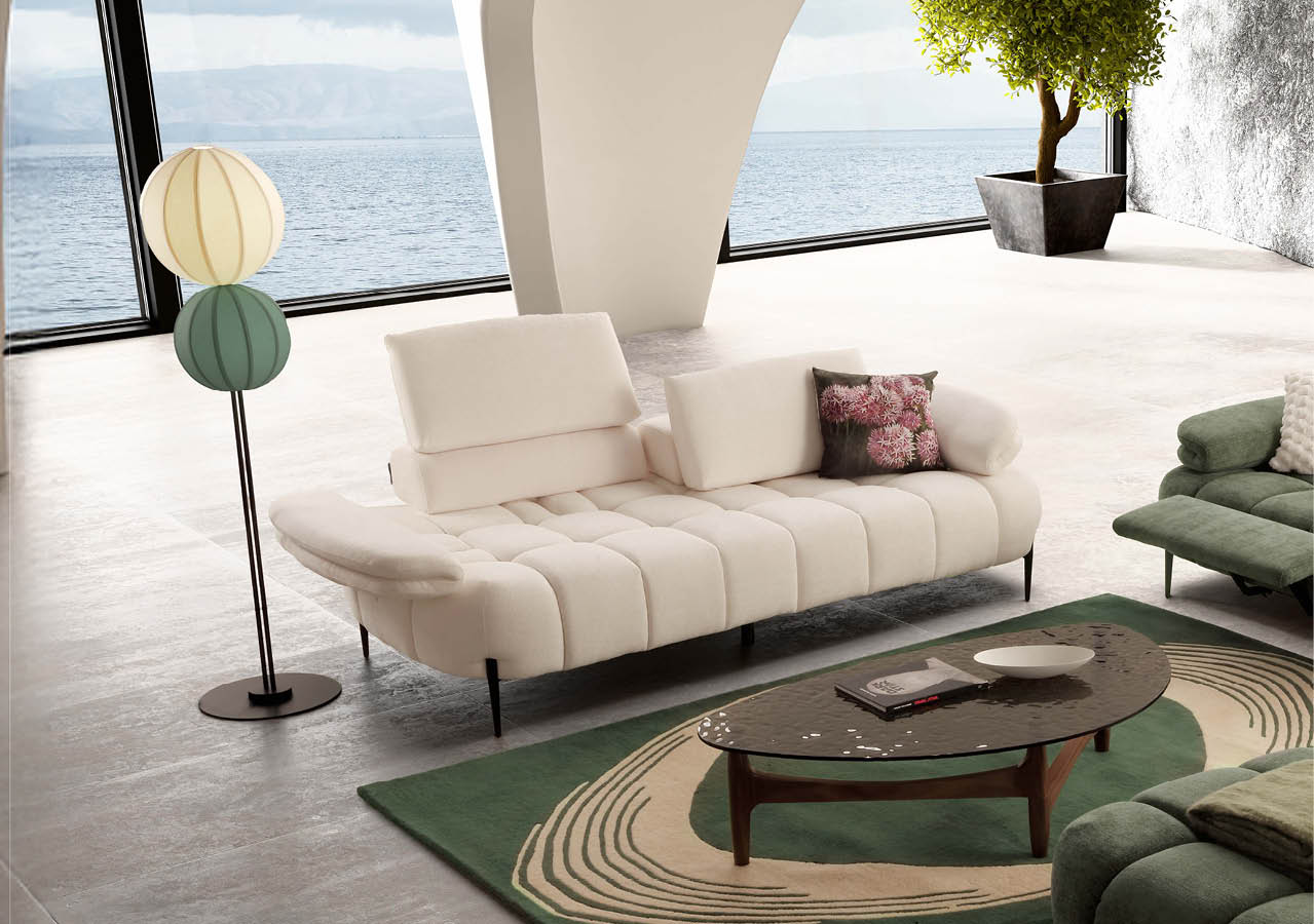 Un salon moderne avec un canap beige, un tapis vert et beige, une table basse en bois, une lampe sur pied   deux abat-jours color s et une grande baie vitr e donnant sur une vue sur l'eau.  Description g n r e par IA